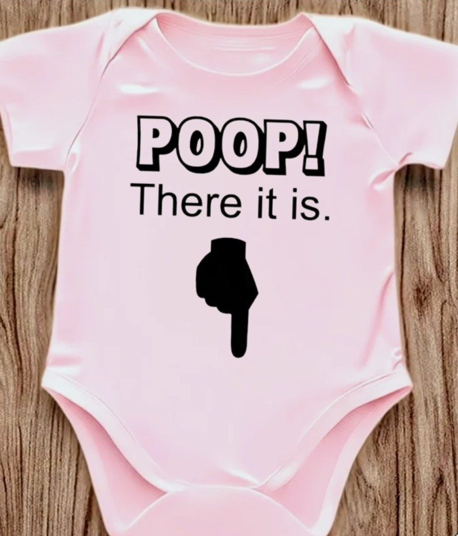 Funny baby onesie with the text 'Poop! There it is' on a wooden background
